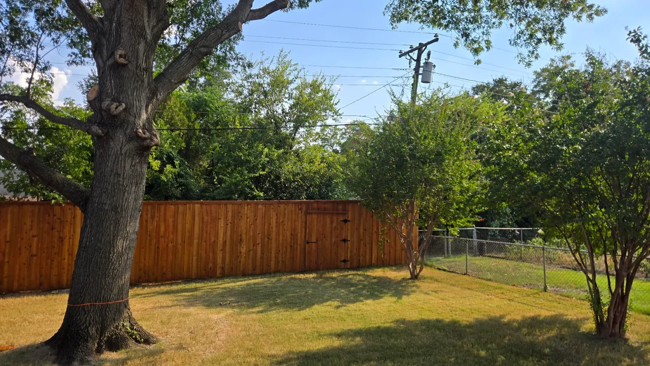 8 ft tall western red cedar board on board with double trim. Cedar split rail fence around the concrete patio. Fences stain with Golden cedar color stain. — Addison