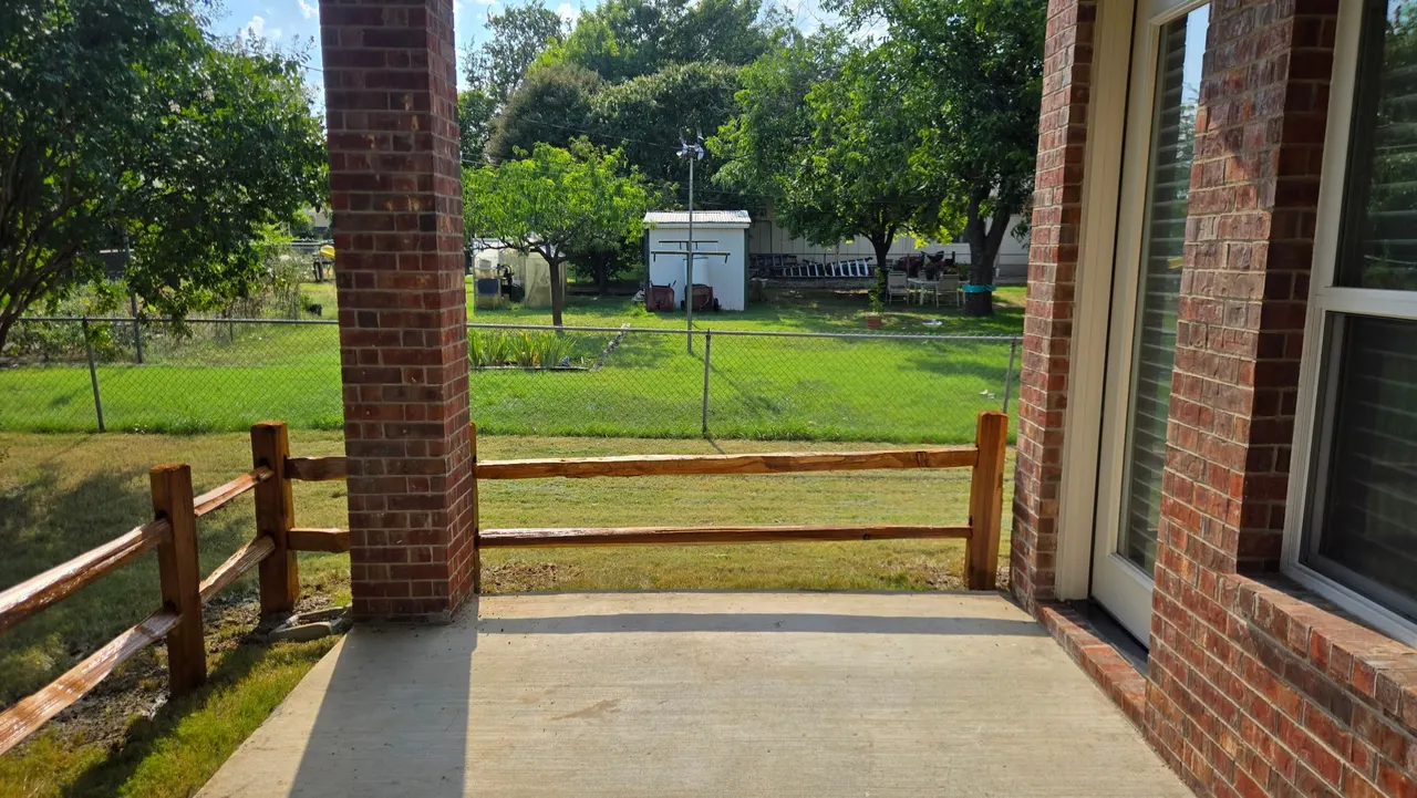 8 ft tall western red cedar board on board with double trim. Cedar split rail fence around the concrete patio. Fences stain with Golden cedar color stain. — Addison