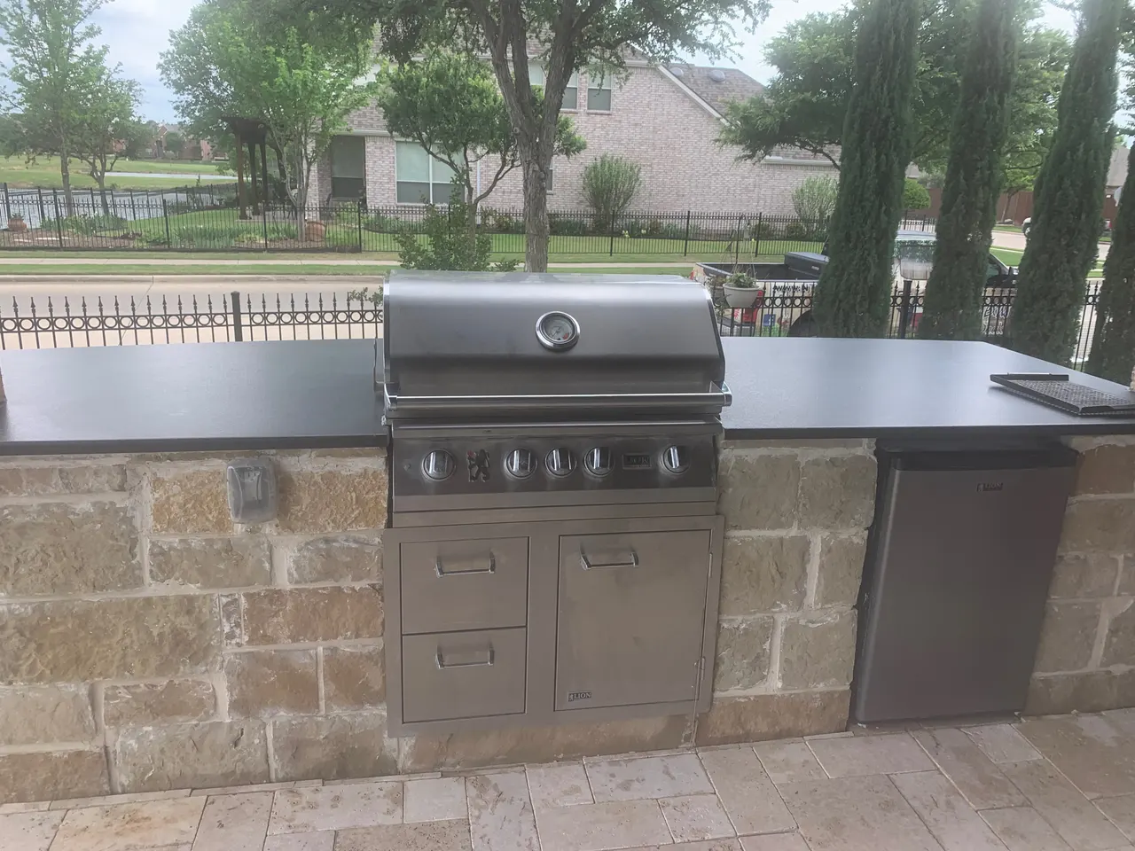 Outdoor kitchen with Oklahoma stone and granite countertops. Bull brand propane  4 burner grill, bull brand mini fridge — Garland