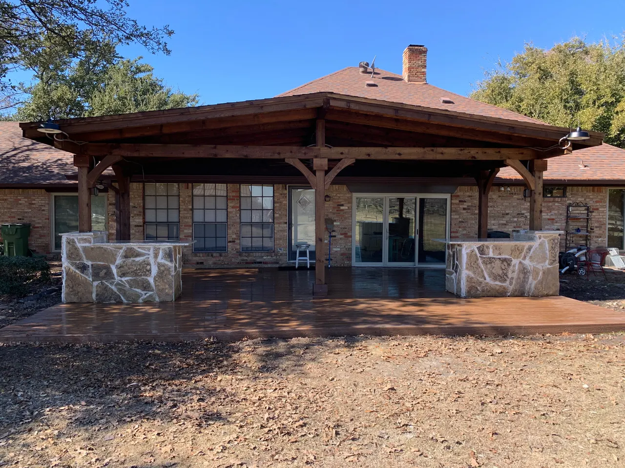 Western red cedar gable style patio with a composite deck. Oklahoma flagstone bars and benches with granite countertops. outdoor kitchen — Plano