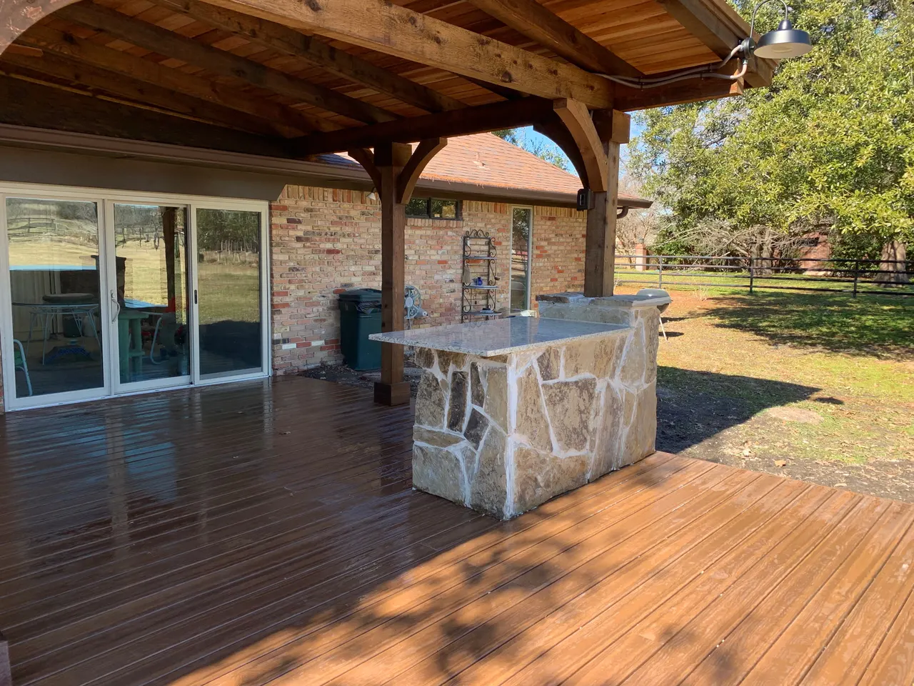 Western red cedar gable style patio with a composite deck. Oklahoma flagstone bars and benches with granite countertops. outdoor kitchen — Plano